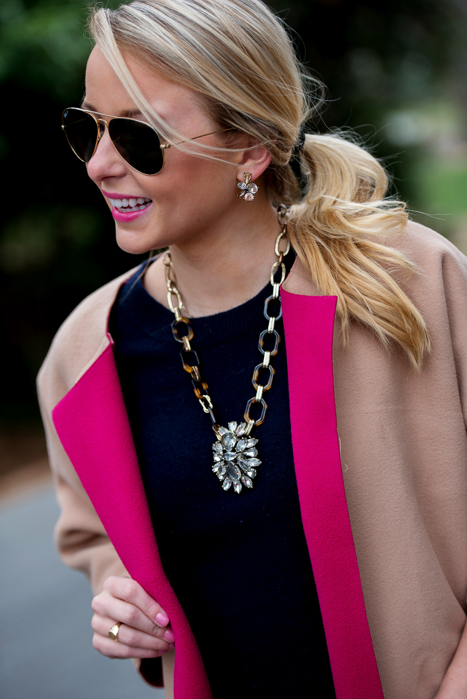 Amy Littleson from I Believe in Pink in navy cashmere crewneck sweater, and a camel and hot pink coat