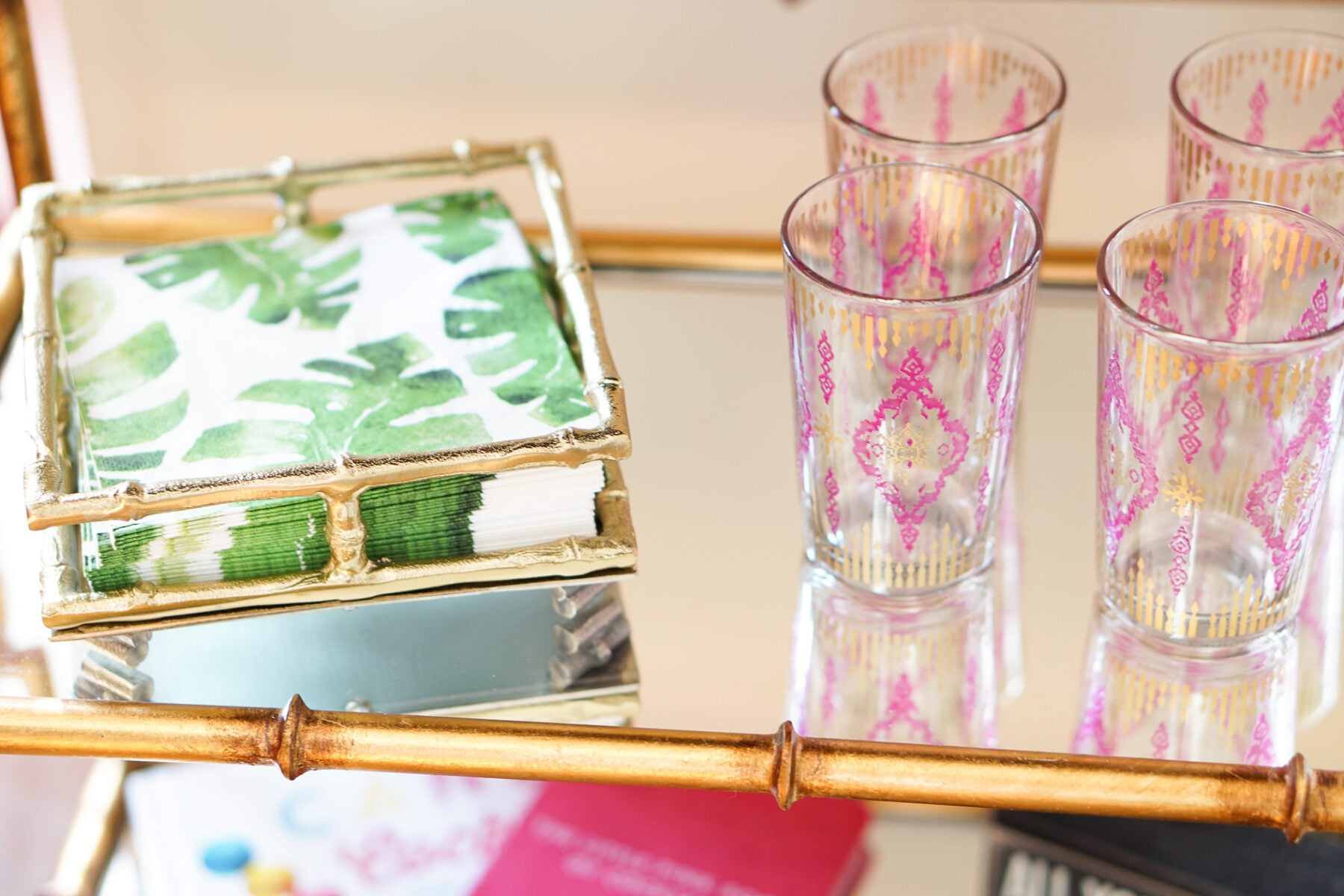 Gold bamboo bar card with pink and green banana leaf decorations in Philadelphia apartment