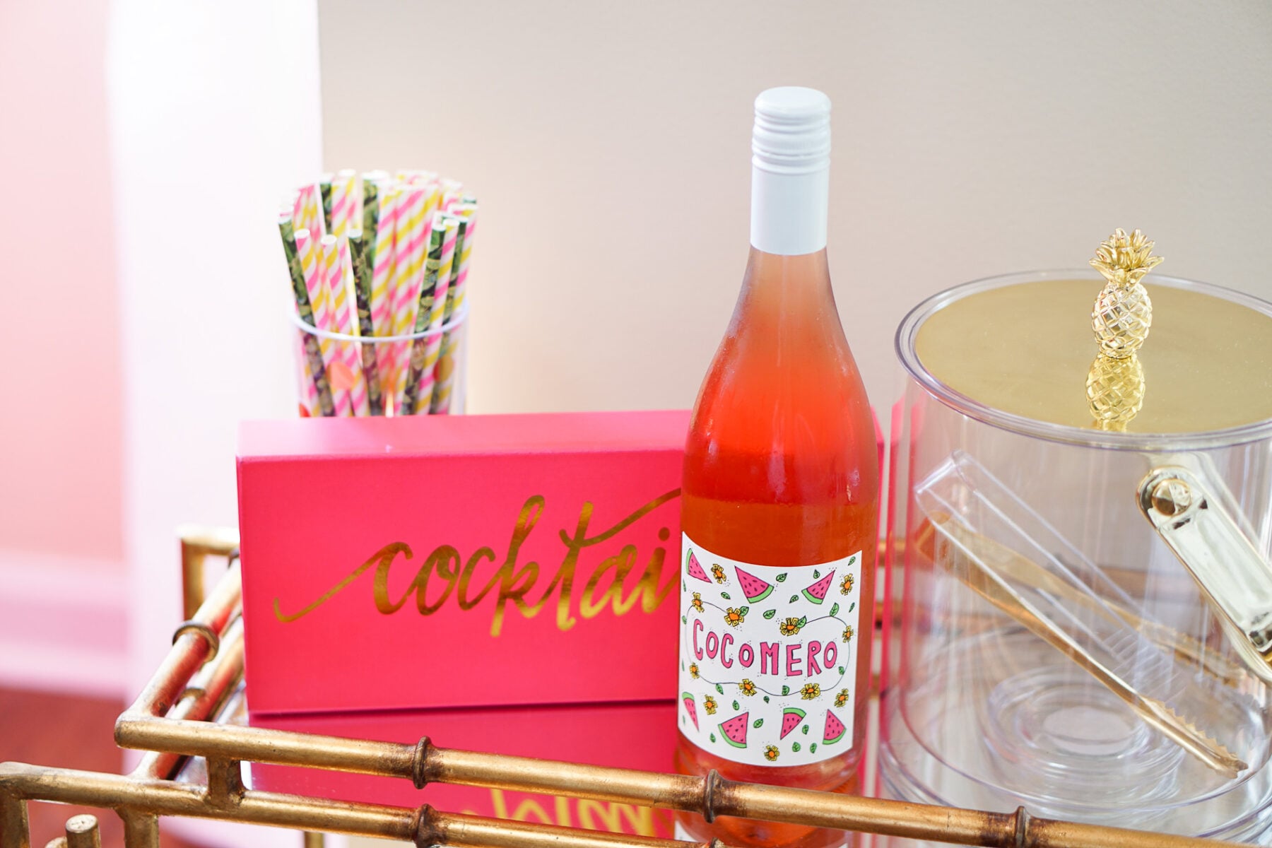 Gold bamboo bar card with pink and green banana leaf decorations in Philadelphia apartment