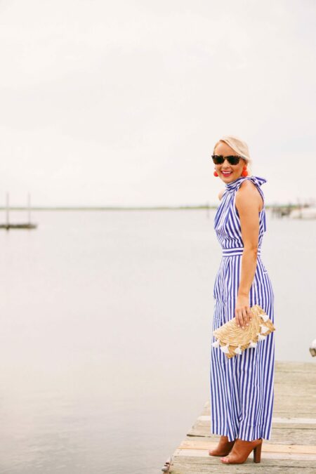 J. Crew striped jumpsuit with coral statement earrings and tassel clutch